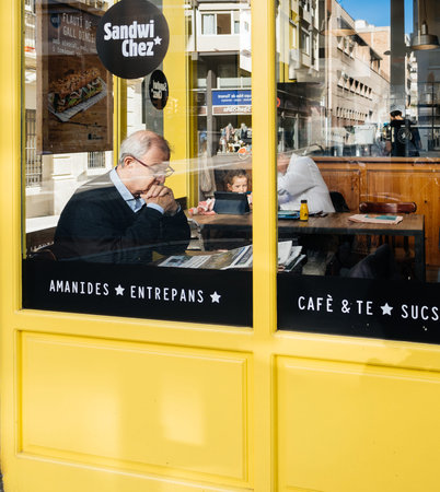 Barcelona, Spain - Nov 12, 2017: Senior man reading newspaper in Spanish cafe with father and...