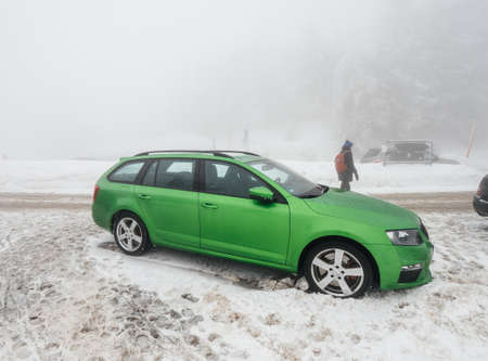MUMMELSEE, GERMANY - JAN 26, 2019: Woman parking green Skoda Octavia RS car Combi estate car in snow covered parking - bad weather in Black Forest Mountainsのeditorial素材