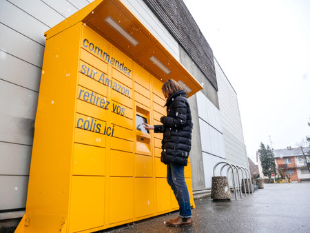 Strasbourg, France - Feb 8, 2018: Young woman using Amazon Locker the self-service parcel delivery...