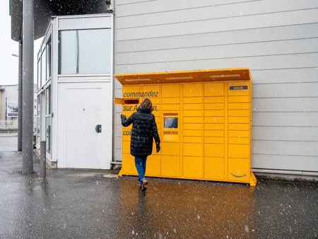 Strasbourg, France - Feb 8, 2018: Young woman using Amazon Locker the self-service parcel delivery...