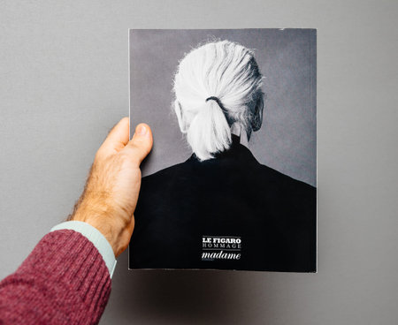 Paris, France - Feb 23, 2019: Man showing French Le Figaro hommage tribute magazine covering Karl...