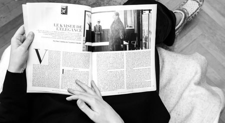 Paris, France - Feb 23, 2019: Woman reading French magazine covering Karl Lagerfeld death, iconic...