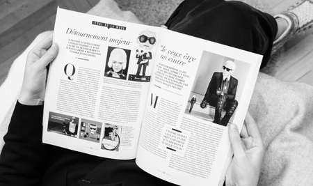 Paris, France - Feb 23, 2019: Woman reading French magazine covering Karl Lagerfeld death, iconic fashion designer died aged 85 - black and whiteのeditorial素材
