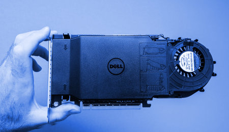 Paris, France - Oct 14, 201&: Man IT guy holding against gray background a powerful Dell Ultra-Speed...