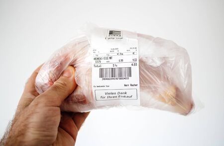 Karlsruhe, Germany - Mar 12, 2019: Male hand holding plastic package with Edeka supermarket logotype and fresh meat for a total of 4.03 eurosのeditorial素材
