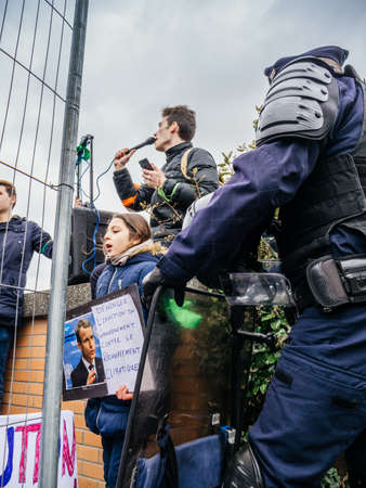 STRASBOURG, FRANCE - MAR 15, 2019: Young french girl with placard portrait of Emmanuel Macron and inefficiency of government against climate change as protesters young man addressing to crowdのeditorial素材