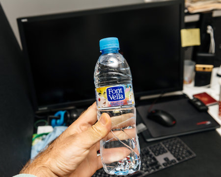 Madrid, Spain - Jun 11, 2018: Man hand holding pet plastic bottle of Font Vella water bootle...