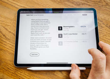 Paris, France - Mar 27, 2019: Man POV at iPad Pro tablet reading on Apple.com website about new Apple Card - presentation of daily cashのeditorial素材