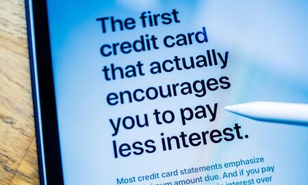 Paris, France - Mar 27, 2019: Man POV at iPad Pro tablet reading on Apple.com website about new Apple Card the first credit card that actually encourages you to pay less interest card blue business color castのeditorial素材