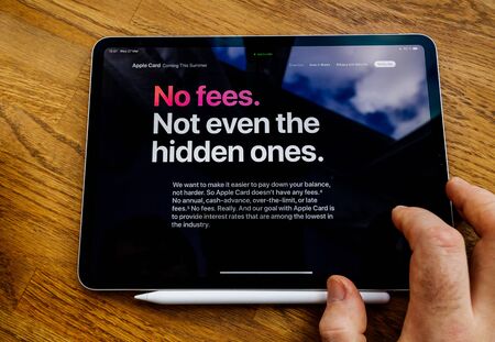 Paris, France - Mar 27, 2019: Man POV at iPad Pro tablet reading on Apple.com website about new Apple Card - no fees no even hidden onesのeditorial素材