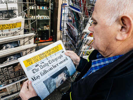 Paris, France - 29 Mar 2019: Newspaper stand kiosk selling press with senior male hand buying latest...