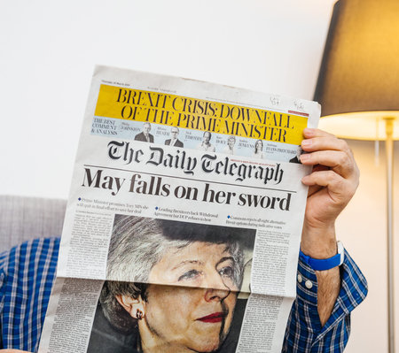Paris, France - 29 Mar 2019: man reading in living room latest british The Daily Telegraph newspaper UK press featuring Theresa may PM on front coverのeditorial素材