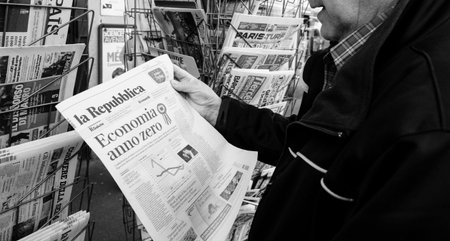 Paris, France - 29 Mar 2019: Newspaper stand kiosk selling press with senior male hand buying latest italian La republica featuring Economia anno zero on front cover black and whiteのeditorial素材