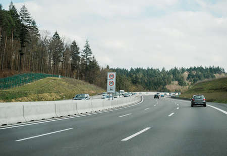 Stuttgart, Germany - Mar 26, 2016: POV Driving fast on German autobahn highway on a clear spring day with perfect road condition and  warning signs for 120 limit speed and 100 during rainy weatherのeditorial素材
