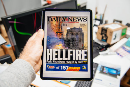 Paris, France - Apr 15, 2019: Man reading Daily News on iPad Pro Apple News Plus digital newspaper...