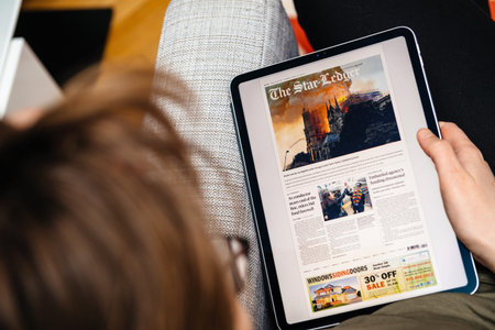 Paris, France - Apr 15, 2019: Woman reading The Star-Ledger on iPad Pro Apple News Plus digital...