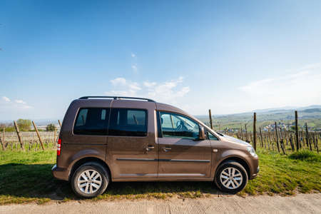 Ribeauville, France - Apr 19, 2019: Side view of topaz brown colored Volkswagen VW Caddy mini van parked on top of vineyards above Ribeauville villageのeditorial素材