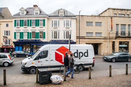 Oxford, United Kingdom - Mar 3, 3017: DPD Delivery Parcel white van in front of Blackwells Art and Poster Shop on Broad street with people students commutingのeditorial素材