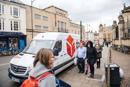 Oxford, United Kingdom - Mar 3, 3017: Pedestrians in front of DPD Delivery Parcel white van in front of Blackwells Art and Poster Shop on Broad streetのeditorial素材