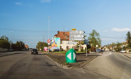 Benfeld, France - Apr 19, 2019: Welcome to Benfeld sign near Strasbourg with multiple road signs to diverse Alsatian directionsのeditorial素材