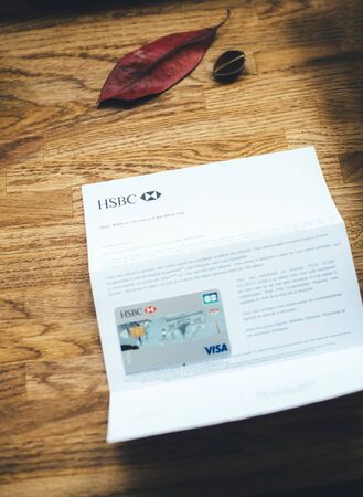 Paris, France - Apr 9, 2017: New HSBC French division featuring Arc de Triumph on the cover Visa Maestro card received and instruction how to use it on wooden table tilt-shift lensのeditorial素材