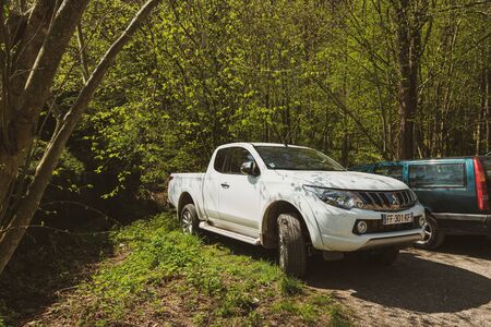 Ribeauville, France - Apr 19, 2019: White Pick-up Mitsubishi and Volvo cars parked in the forest parkingのeditorial素材