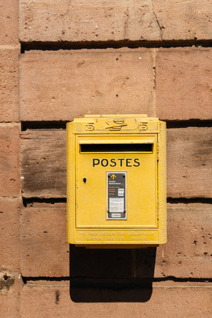Bergheim, France - 19 Apr 2019: Old vintage French La Poste mailbox painted in yellow color seen on...