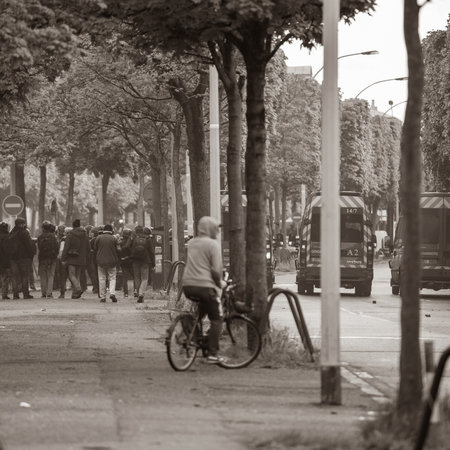 Strasbourg, France - Apr 28, 2019: Rear view of pedestrians looking at police gendarmerie securing Allee de la Robertsau in Strasbourg during Yellow Vests protests in Strasbourgのeditorial素材