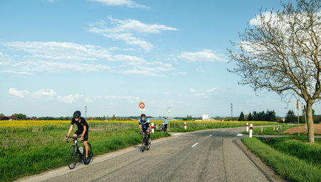 Alsace, France - Apr 19, 2019: Young and adult cyclists exercising fast hard on the modern bikes near the raps fields in Alsaceのeditorial素材