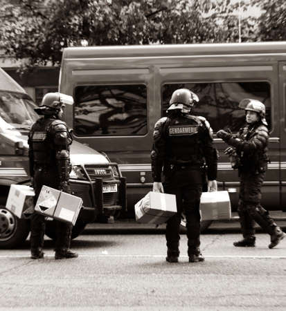 Strasbourg, France - Apr 28, 2019: Square image black and white French Police officers gendarmes distribution to colleagues boxes with 1330-14-548-9477 hand launcher grenades supply for next altercations Yellow vests protestorsのeditorial素材