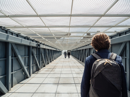 Rear view of young tourist caucasian woman crossing bridge street in central Baku, Azerbaijanの写真素材