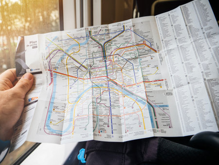 Paris, France - Jan 30, 2018: Man reading in train detailed map of Parisian New Paris Metro Map with...