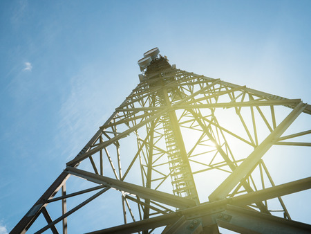 View from below low angle view with high efficiency communication antennas used for civil and military data transmission frequency with cinematic flare sunlightの写真素材