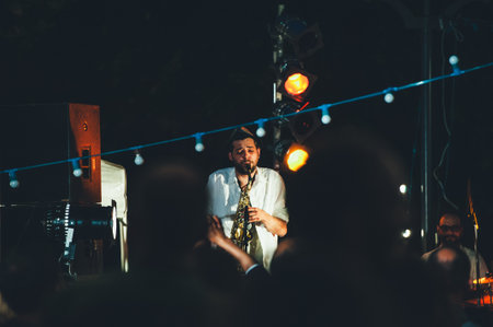 Strasbourg, France - Jun 2, 2012: Man singing at saxophone street concert in central Place Austerlitz in Strasbourg at dusk with hanged lamps illuminationのeditorial素材