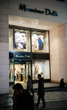 Athens, Greece - 26 Mar 2016: View from the street of customers people shopping inside Massimo Dutti luxury store in central Athens at duskのeditorial素材