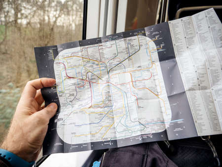 Paris, France - Jan 30, 2018: Hand holding POV map of Parisian New Paris Metro Map with station names and connections commuting from Charle de Gaulle airport to city centerのeditorial素材