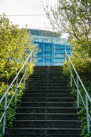 Empty stairs with facade of European Parliament in Strasbourg building seen at the top through green...