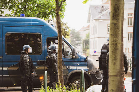 Strasbourg, France - Apr 28, 2019: Side view of police officers near vans securing entrance to Rue Rene Schickele after altercations with Yellow Vests Gilets jaunesのeditorial素材