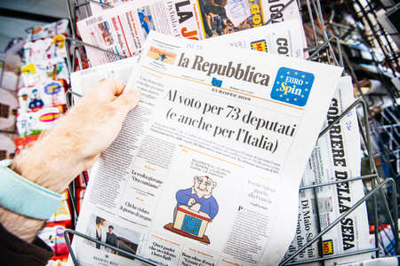 Strasbourg, France - May 27, 2019: Man holding buying newspaper La Repubblica front page on street press kiosk newsstand with the results of 2019 European Parliament electionのeditorial素材