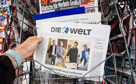 Strasbourg, France - May 27, 2019: Man holding buying Die Welt newspaper front page on street press kiosk newsstand with the results of 2019 European Parliament electionのeditorial素材