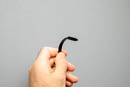 Computer repairman engineer holding new black S-ATA DATA Cable used to connect HDD hard disk drive or SSD Solid driveの写真素材