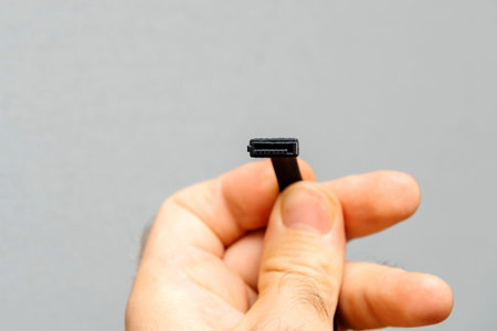 Computer repairman engineer holding new black S-ATA DATA Cable used to connect HDD hard disk drive...