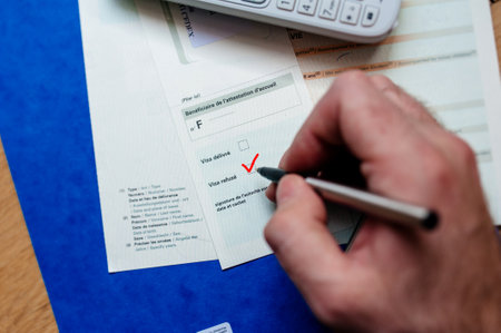 Paris, France - Apr 10, 2013: Man hand filling Attestation daccueil Proof of Accommodation for visitors from other countries to France with visa refusedのeditorial素材