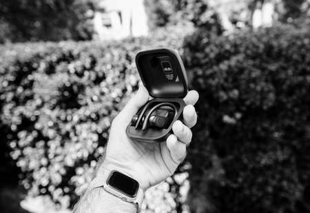 Paris, France - Jun 17, 2019: Powerbeats Pro Beats by Dr Dre wireless high-performance earphones charging case after unboxing man hand holding admiring the new music device black and whiteのeditorial素材