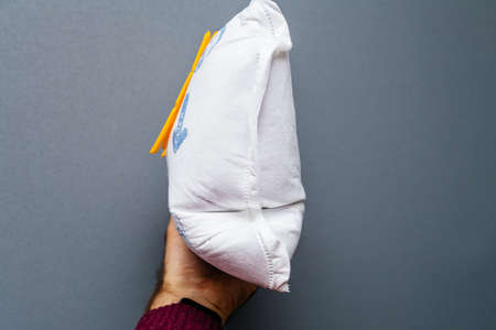 Paris, France - May 16, 2019: Man hand holding against gray background old full with dust Swirl Vacuum Cleaner Bags model S67 for Siemens and Bosh - side viewのeditorial素材