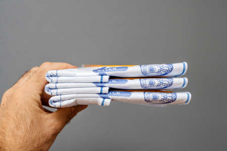 Paris, France - May 16, 2019: Man hand holding against gray background stack with new Swirl Vacuum Cleaner Bags model S67 for Siemens and Bosh - German quality productのeditorial素材