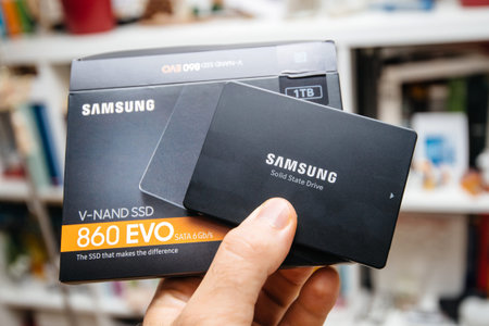 Paris, France - May 18, 2019: man hand holding cardboard box and new SSD Solid state drive disk from...