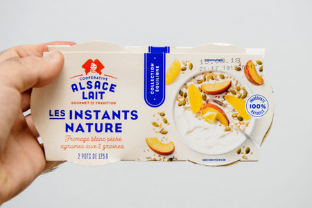 Strasbourg, France - Aug 11, 2018: Man hand holding Alsace Lait les Instants Nature white fromage...