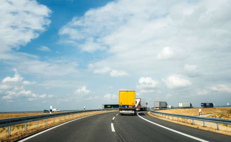 Koln, Germany - Aug 15, 2018: Multiple cargo trucks trailers driving on German autobahn entering roundaboutのeditorial素材