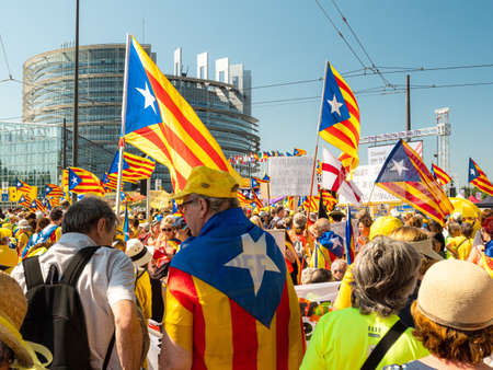 Strasbourg, France - Jul 2 2019: Group of people holding Estelada Catalan separatist flags demonstrate protest front of EU European Parliament against exclusion of three Catalan elected MEPsのeditorial素材